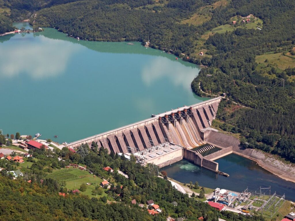 large dam surrounded by forests